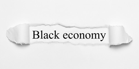 Black economy on white torn paper