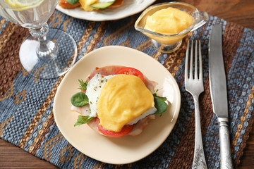 Plate with tasty egg Benedict on table