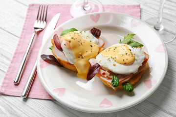 Plate with tasty eggs Benedict on table