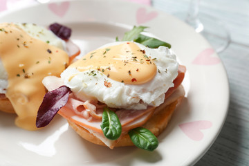 Tasty eggs Benedict on plate, closeup