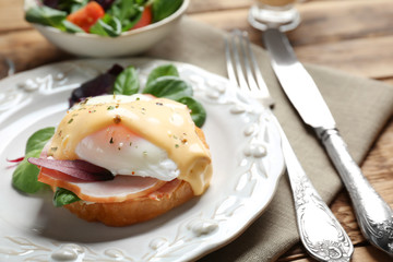 Plate with tasty egg Benedict on table