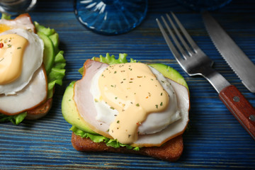Tasty eggs Benedict served on wooden board