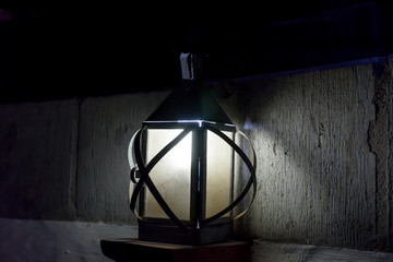 Fototapeta na wymiar Vintage old luminous lantern lamp in dark room