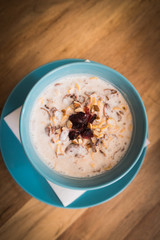 Delicious nutritious and healthy oatmeal with dried fruit on antique wood table