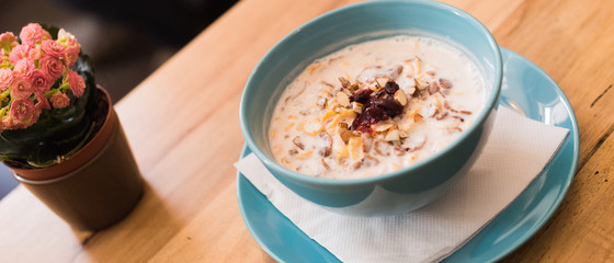 Delicious nutritious and healthy oatmeal with dried fruit on antique wood table