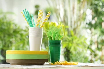 Tuinposter Plastic ware on table outdoors © Africa Studio