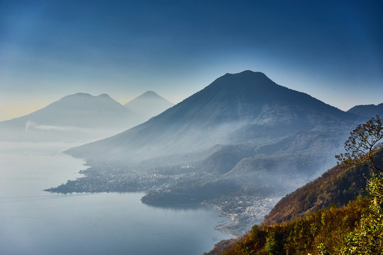 Highlands with volcanoes at Lake Atitlan in Guatemala / Foggy morning at lake in Guatemala in the morning hours