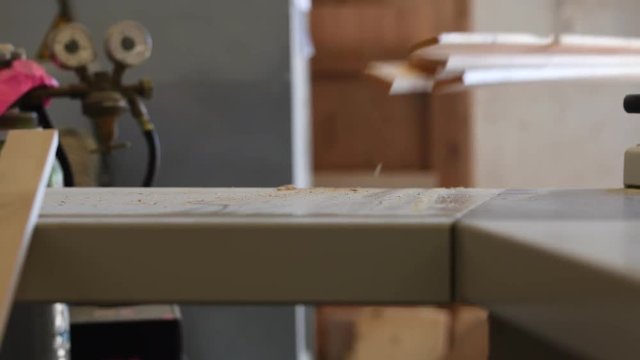 Handwerker zerkleinert Leisten mit einer Tischkreissäge