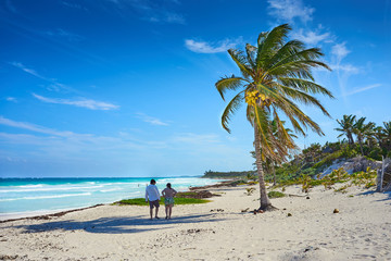 Couple at untouched paradise under marvelous coconut trees / Tropical beach of Tulum in Mexico