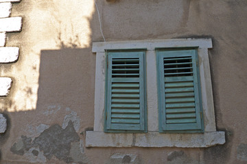 Fototapeta na wymiar An old blue green window shutter in Croatia