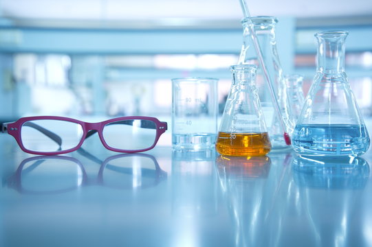 red eye glasses in science laboratory background with flask