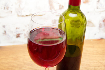 Bottle of red wine with glass ready to pour