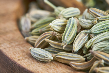 Closeup of dried fennel seeds in wooden spoon