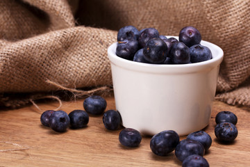 Pot of blueberries on a rustic background