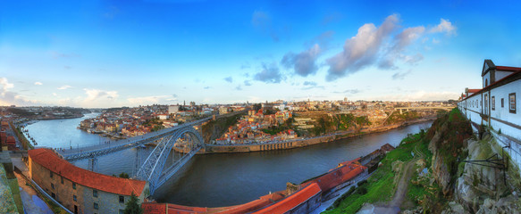 Aerial evening wide angle panoramic cityscape. View of the historical part of town Porto. Douro river and the Dom Luis Bridge. Porto. Portugal.