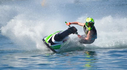 Abwaschbare Fototapete Wasser Motorsport Jet-Ski-Konkurrent fährt mit hoher Geschwindigkeit in Kurven und erzeugt viel Spray.