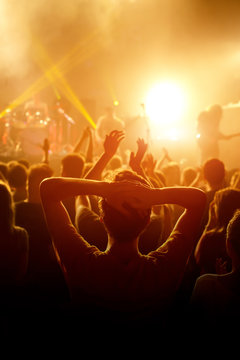 Rock Concert, Cheering Crowd In Front Of Bright Colorful Stage Lights, Hands Behind The Head With Pleasure From The Show