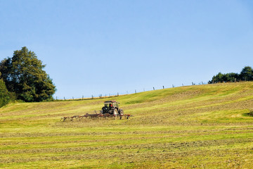 Tractor with plough doing some agricultural seasonal work in field