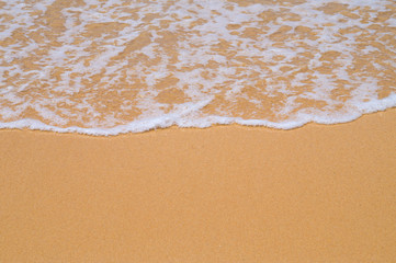 Beach yellow sand covered with wave white foam background.