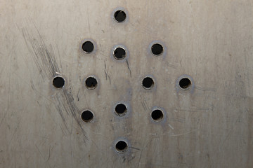 Metal plate with many circular holes background.