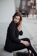 Young businesswoman sitting with vintage and elegant dress outside. Lifestyle