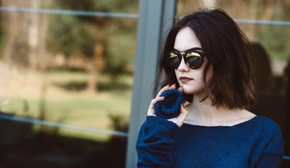 Young girl holding woolen brooch on terrace.