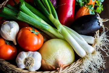 Fresh Organic Vegetables in Wicker Basket on Dark Wooden Background