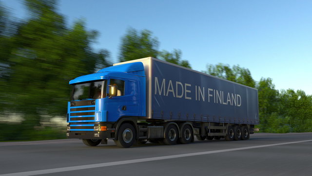 Speeding freight semi truck with MADE IN FINLAND caption on the trailer. Road cargo transportation. 3D rendering