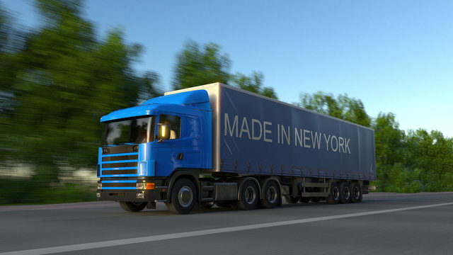 Speeding freight semi truck with MADE IN NEW YORK caption on the trailer. Road cargo transportation. 3D rendering