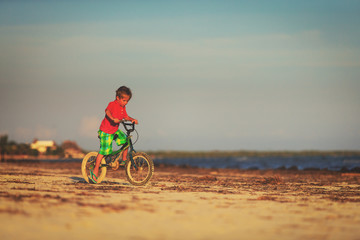 Fototapeta na wymiar little boy riding bike at beach