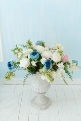 Vase with flowers on a white wall background