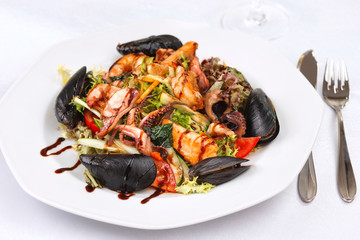 Seafood salad on a white plate isolated