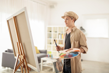 Teen painter looking at a canvas at home
