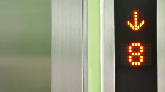 Close-up of an elevator's digital floor indicator showing it descending