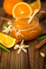 Orange, orange jam on rustic wood background