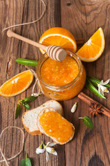 Obraz na płótnie Canvas Orange, orange jam and croissant on rustic wood background