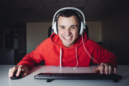 Funny boy with headphones at home playing games on the computer.