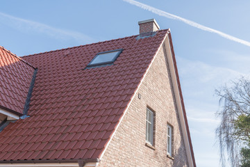 Dach mit einem Dachfenster und roten Dachpfannen