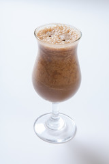 Delicious milkshake with a leaf of mint on top on a white background