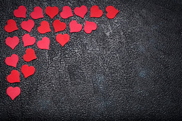 Red paper hearts on dark background with space for text