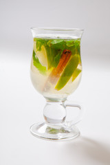 Glass of tea with mint,cinnamon and lime isolated on white