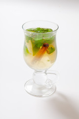 Glass of tea with mint,cinnamon and lime isolated on white