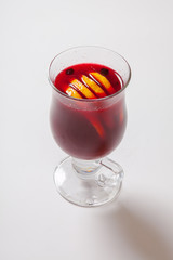 Tall transparent glass with raspberry and citrus tea.
