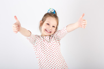 Portrait of little  beautiful and confident girl showing thumbs up