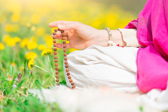 Woman reads the yoga mantra during practice with the mala