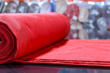 roll of red material lying on the cutting table in the Studio on tailoring of textiles