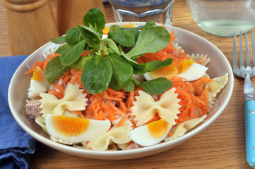 Salade composée avec des farfalles, des œufs durs, de la mâche et des carottes râpées