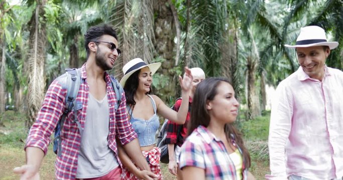 People Group With Backpacks Trekking On Forest Path, Young Men And Woman On Hike In Tropical Palm Tree Park Tourists Slow Motion 60