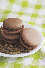 Chokolate macarons on a plate with green coffee