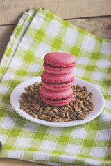 Pink macarons on a plate with green coffee